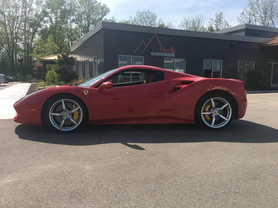 Red Ferrari 488 parked outside a commercial building