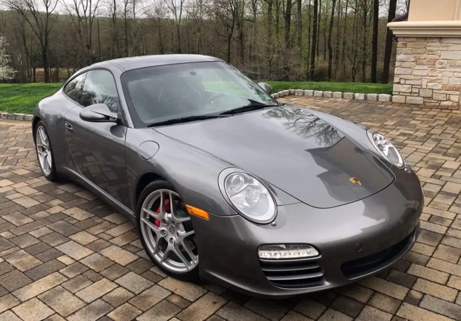 Gray Porsche 911 Carrera parked on a paver driveway